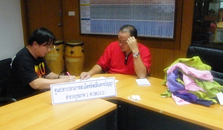 An officer takes down details from suspect Korn Thanormsupthawee.